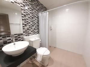 a white bathroom with a sink and a toilet at Zleep D Hotel in Udon Thani