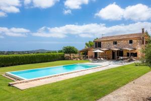 een grote achtertuin met een zwembad en een huis bij Sa Pleta in Manacor