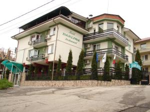 a large white building with a fence in front of it at Darling Hotel in Sofia