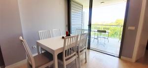 a white table and chairs in a room with a balcony at Apartamentos Verger de Denia in Els Poblets