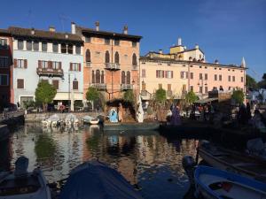 grupa budynków obok zbiornika wodnego z łodziami w obiekcie Casa Mariposa w mieście Desenzano del Garda
