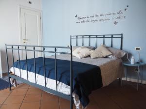 sypialnia z łóżkiem z cytatem na ścianie w obiekcie Casa Mariposa w mieście Desenzano del Garda
