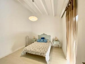 1 dormitorio con cama y techo blanco en Cal SIMO, en Poboleda