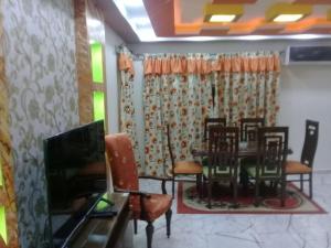 a dining room with a table and chairs and a television at Stanley Apartment - Sea View - Free Parking in Alexandria