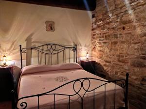 - une chambre avec un lit dans un mur en pierre dans l'établissement Frigino Agriturismo, à Molino Abbadia