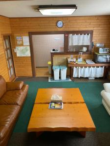 a living room with a couch and a coffee table at Guest House Wind Inn Hakuba in Hakuba