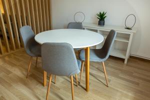 a table and four chairs around a white table at Lagom Hotel in Bucharest