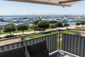 ein Balkon mit Stühlen und Blick auf einen Yachthafen in der Unterkunft Apartment Bellavista Sea View in Umag