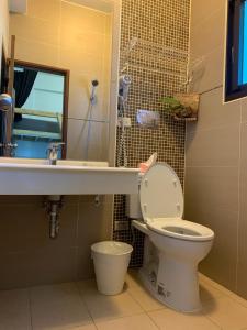 La salle de bains est pourvue de toilettes, d'un lavabo et d'un miroir. dans l'établissement Wave backpackers, à Toucheng