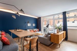 ein Wohnzimmer mit einem Tisch und einem Sofa in der Unterkunft NEW - Appt style le Corbusier avec Balcon - 8 pers in Paris