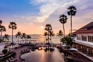 北芭堤雅的住宿－Pullman Pattaya Hotel G，享有棕榈树和游泳池的度假村景色。