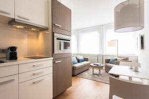 a kitchen and living room with a couch and a table at Brera Serviced Apartments Frankfurt Oper in Frankfurt/Main