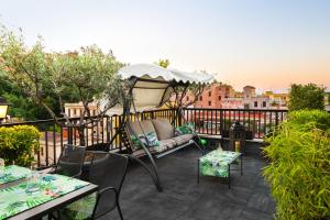 eine Terrasse mit einem Sofa und einem Sonnenschirm auf dem Balkon in der Unterkunft Trilussa Palace Hotel Congress & Spa in Rom