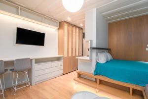um quarto com uma cama, uma secretária e uma televisão em Liston Boutique Suites by CorfuEscapes em Corfu Town