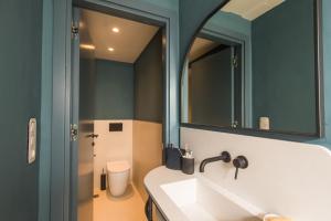 ein Badezimmer mit Waschbecken und Spiegel in der Unterkunft Liston Boutique Suites by CorfuEscapes in Korfu-Stadt + 25 Fotos