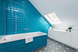 a bathroom with blue tiles and a bath tub at City Centre, Newly Refurbished Stylish Apartment in Edinburgh +25 photos