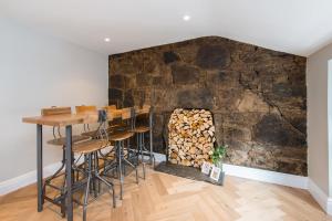a room with a stone wall with a bar and stools at City Centre, Newly Refurbished Stylish Apartment in Edinburgh