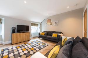 a living room with a couch and a tv at City Centre, Newly Refurbished Stylish Apartment in Edinburgh