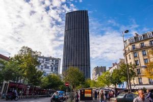 un alto edificio su una strada cittadina con persone e automobili di NEW - Appt style le Corbusier avec Balcon - 8 pers a Parigi