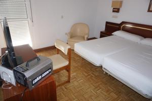 パロス・デ・ラ・フロンテーラにあるHotel Santa Maríaのベッドルーム(ベッド1台、テレビ、椅子付)