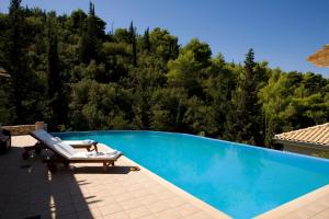 una piscina con un sillón en un patio en VILLA TIMOKLIA en Tsoukaládhes