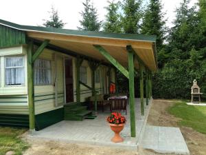 eine Veranda eines Hauses mit einer Blumenvase in der Unterkunft Dar Kalu Jas in Kal