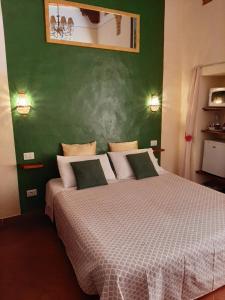 1 dormitorio con 1 cama grande y pared verde en Locazione Turistica Totti, en San Gimignano