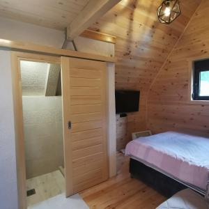 a bedroom in a log cabin with a bed and a television at Bosaca in Žabljak
