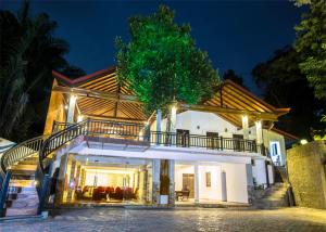 a large white house with a balcony at night at Grand Casa in Kandy