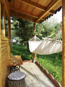 a porch with a hammock and a table at Relax Eaza - Casa cu Hamac in Constanţa