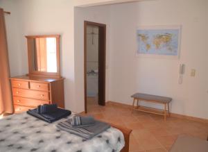 a bedroom with a bed and a dresser and a mirror at Casa Flora T1 - Vila do Bispo in Vila do Bispo