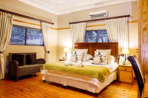 1 dormitorio con 1 cama, 1 silla y ventanas en Nobis House, en Bloemfontein