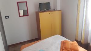a bedroom with a yellow cabinet with a tv on it at Sealand in Nunziata