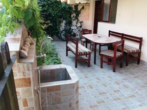 a patio with a table and chairs and a table and a table and chairs at Primorski Briz Guest House in Primorsko