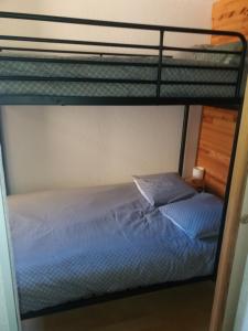 a bottom bunk bed with a blue bedsheet and a pillow at La Foux d'Allos in La Foux