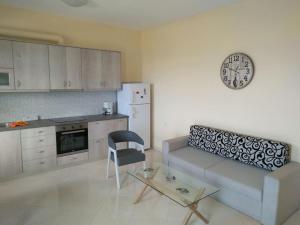 a living room with a couch and a clock on the wall at villa roses-mourteri in Mourteri