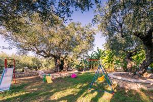 un parque infantil en un patio con árboles en Small Village Residences, en Akrotiri