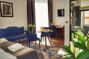 een woonkamer met een blauwe bank en een tafel bij Shalom Kazimierz in Krakau