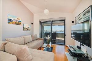 ein Wohnzimmer mit Couch und Flachbildfernseher in der Unterkunft Apartment Bellavista Sea View in Umag