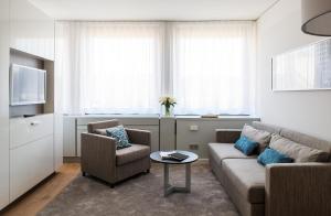 sala de estar con sofá, 2 sillas y mesa en Brera Serviced Apartments Frankfurt Oper, en Frankfurt