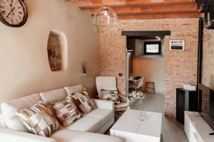 a living room with a couch and a clock on the wall at Casa Rural Turgalium in Trujillo