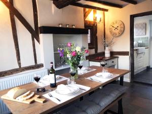 una mesa de madera con copas de vino y flores. en Millie's Cottage, en Finchingfield