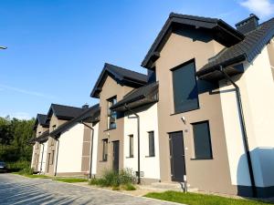 una fila de casas con techos negros en Domki letniskowe Aqua, en Mielno