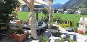 a pergola with a bench in a garden at Großglocknerappartement in Kals am Großglockner