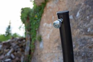 a black pole with a bottle on it next to a wall at Villa MAY in Gostinjac