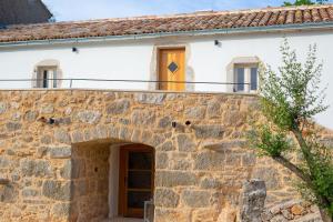 an external view of a stone house with a balcony at Villa MAY in Gostinjac