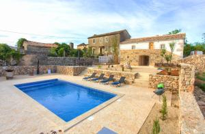 una piscina en un patio con una casa en Villa MAY en Gostinjac