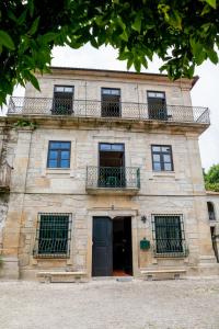 an old stone building with windows and a balcony at Casa do Convento in Arcos de Valdevez