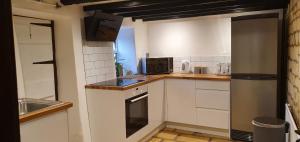 uma pequena cozinha com armários brancos e um micro-ondas em Quirky Cottage - Dogs Welcome - Free 24 hr Cancellation's em Corsham