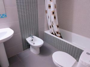 uma casa de banho com um WC branco e um lavatório. em Principado Centro Alquilevante em Benidorm